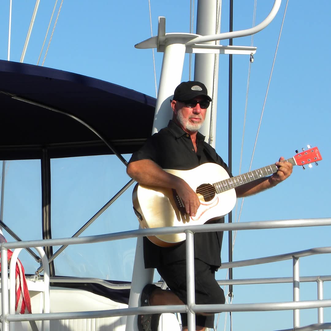 Capt Bob playing guitar on the water in Oriental, NC